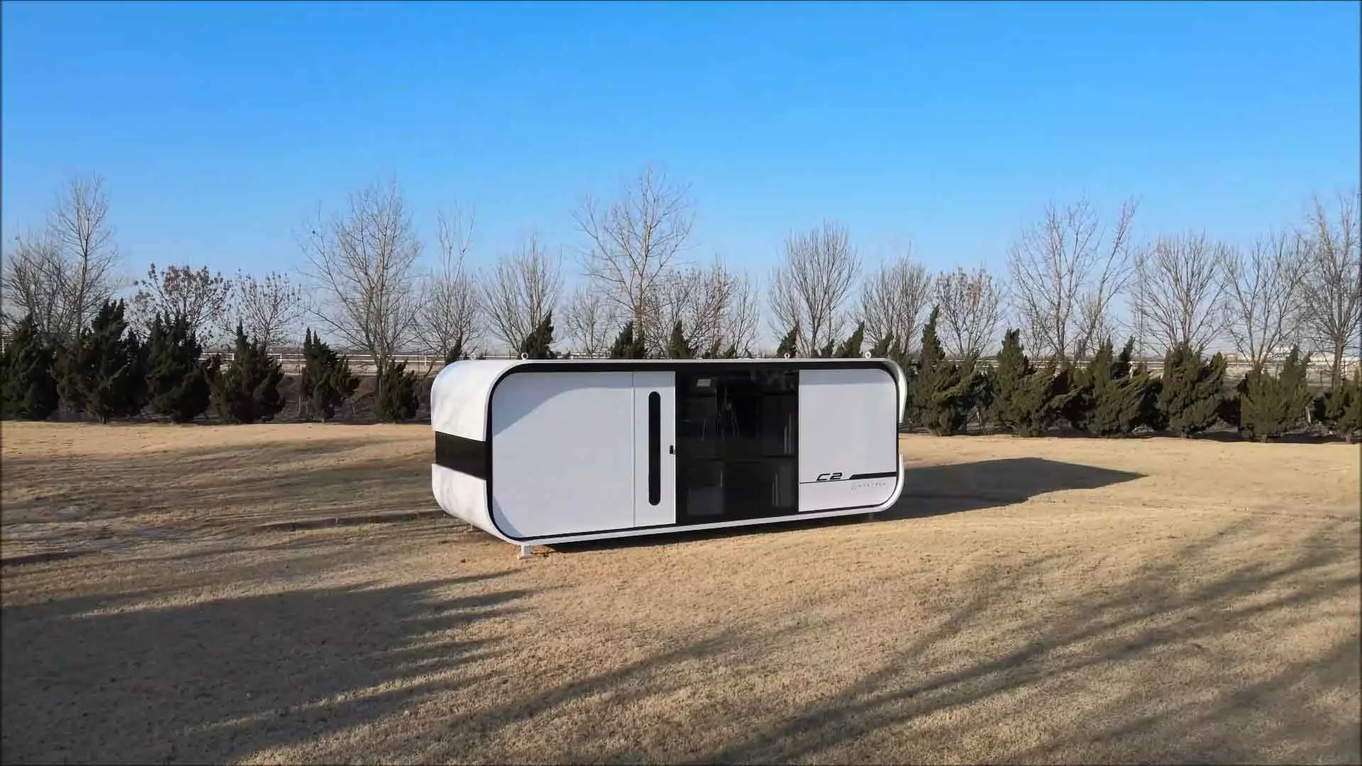Exterior view of the Nestron Cube Two with a white rounded facade, dark trim, and large windows