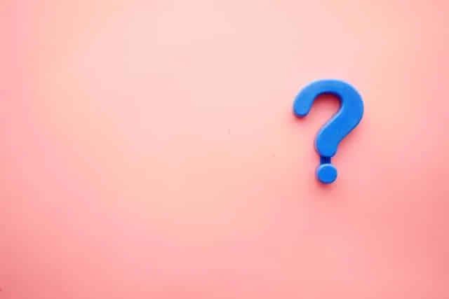 Blue question mark on a soft pink background representing financial uncertainty or debt questions