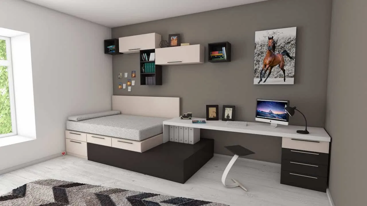 Modern backyard studio interior with a desk, built-in shelving, wall-mounted storage, and neutral finishes