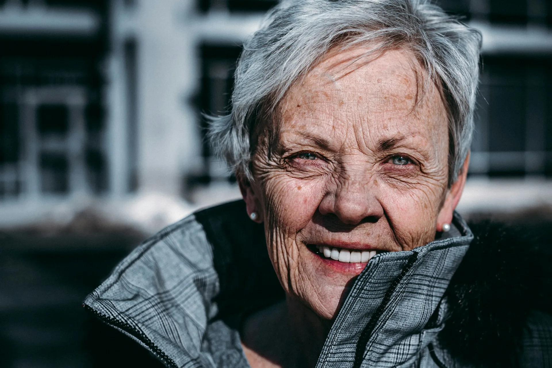 Portrait of a smiling older woman with short gray hair outdoors