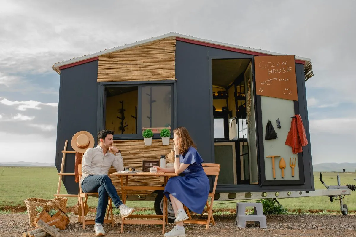 People relaxing outside a modern ADU with a covered patio and outdoor seating