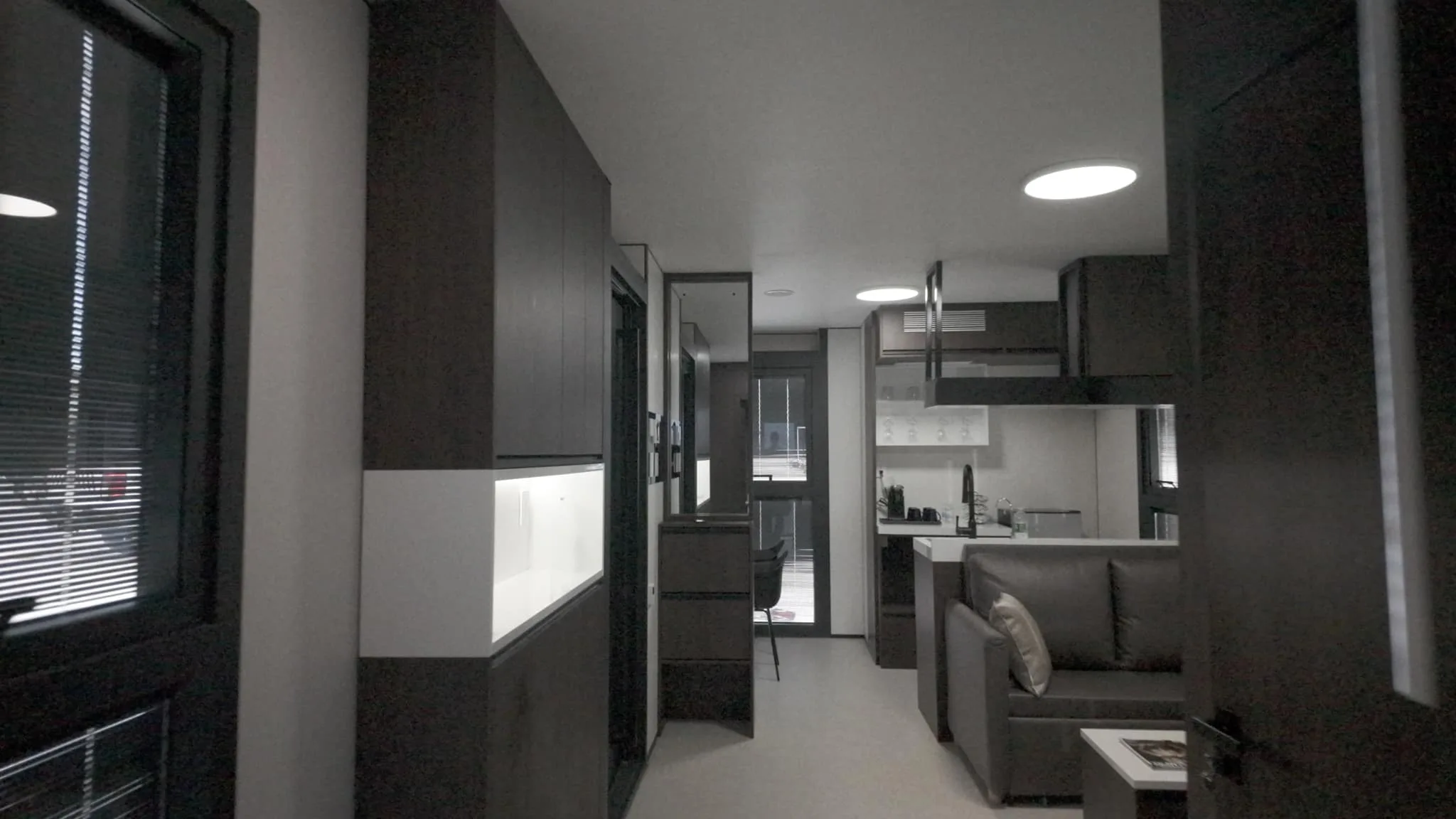 Nestron modular home interior hallway leading to open kitchen and living room with sofa