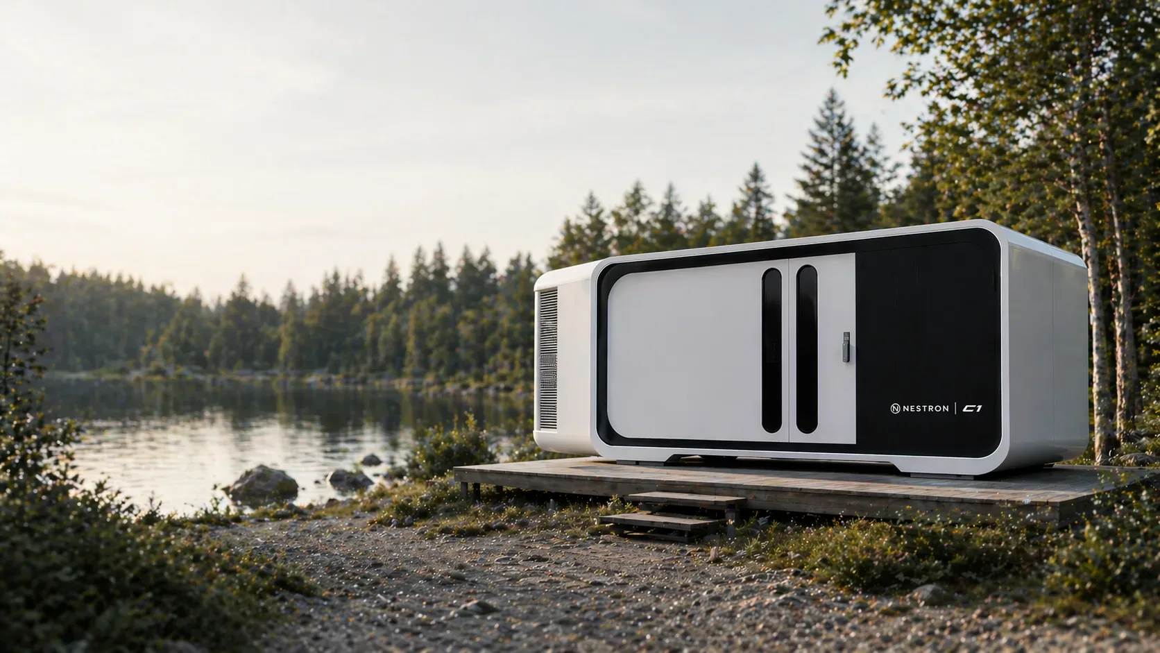 Exterior view of a white modular home on a gravel site surrounded by nature