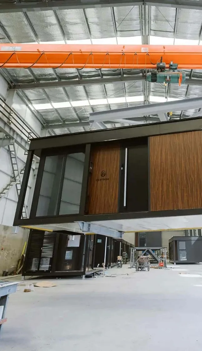 Nestron modular home under construction inside factory with crane, build and deliver step