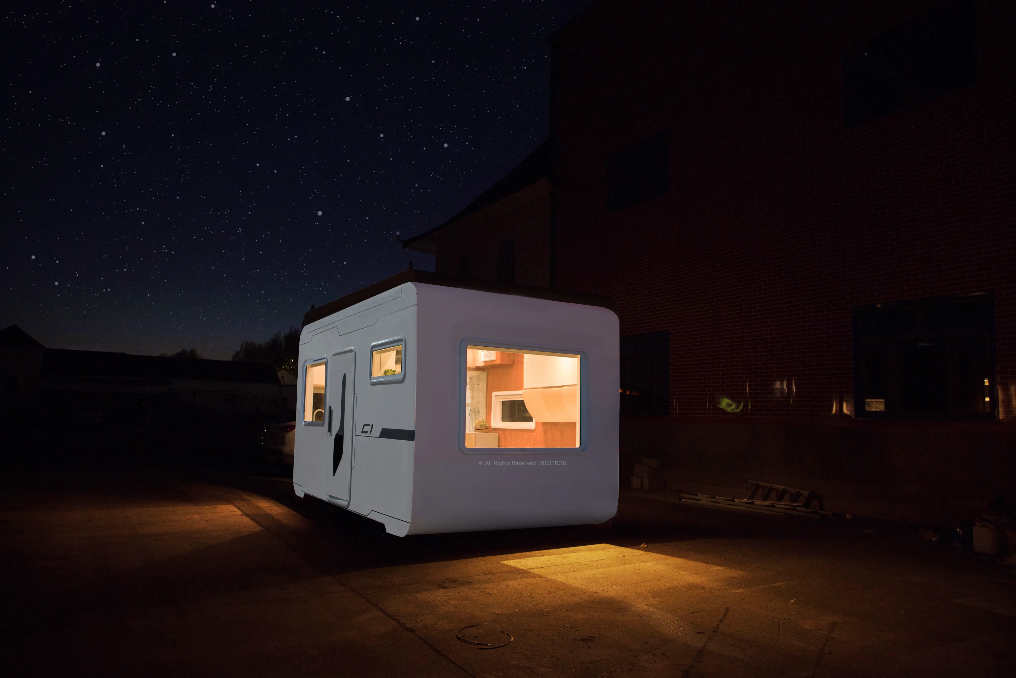 Exterior night rendering of the Nestron Cube One with illuminated windows and exterior lighting