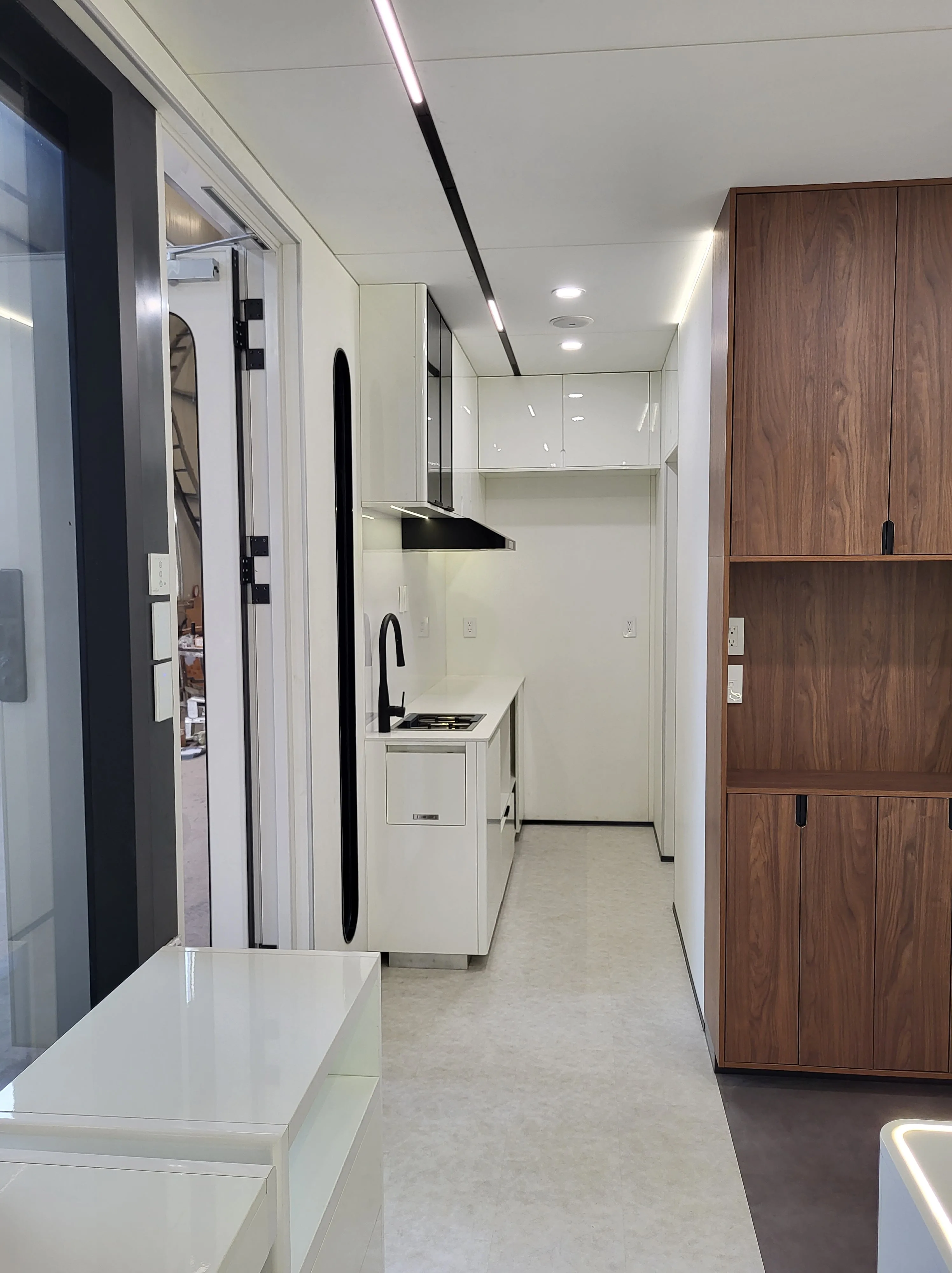 Nestron Cube One interior rendering showing the kitchen, built-in storage, and adjacent bathroom area