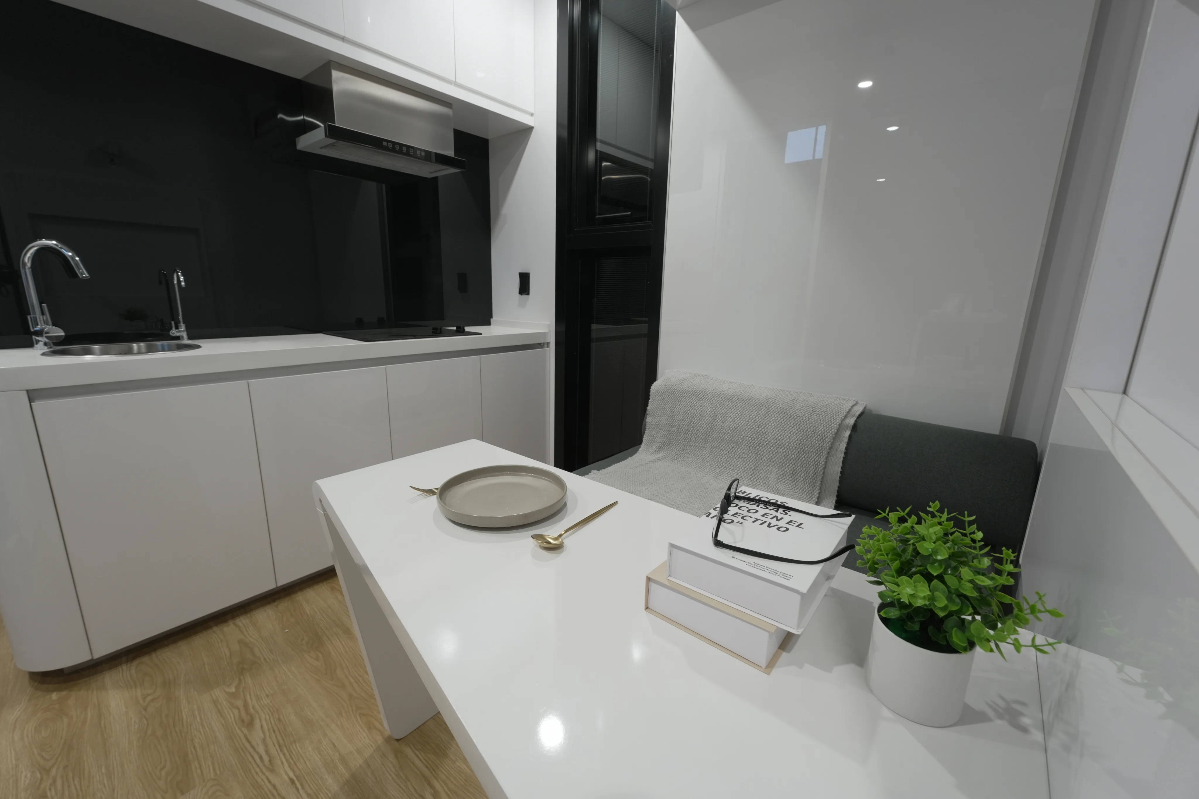Nestron modular home white kitchen and dining area with sofa, sustainability feature