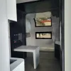 Nestron Cube Two X dinette area with a white fold-out table, black overhead cabinets, and dual windows