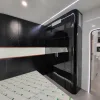 Nestron Cube Two X bedroom rendering with a bed, dark built-in wall unit, and integrated shelving