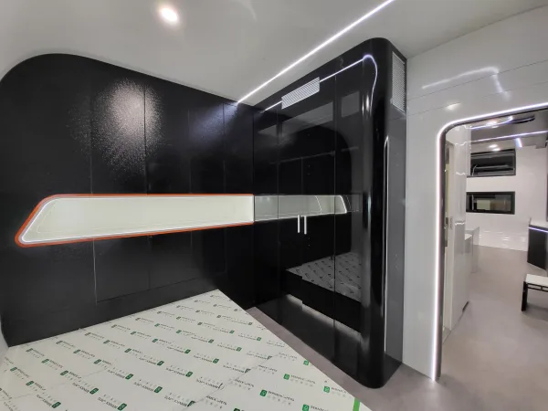Nestron Cube Two X bedroom rendering with a bed, dark built-in wall unit, and integrated shelving