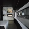 Nestron Cube Two X interior rendering showing a panoramic window, white table, and compact living space