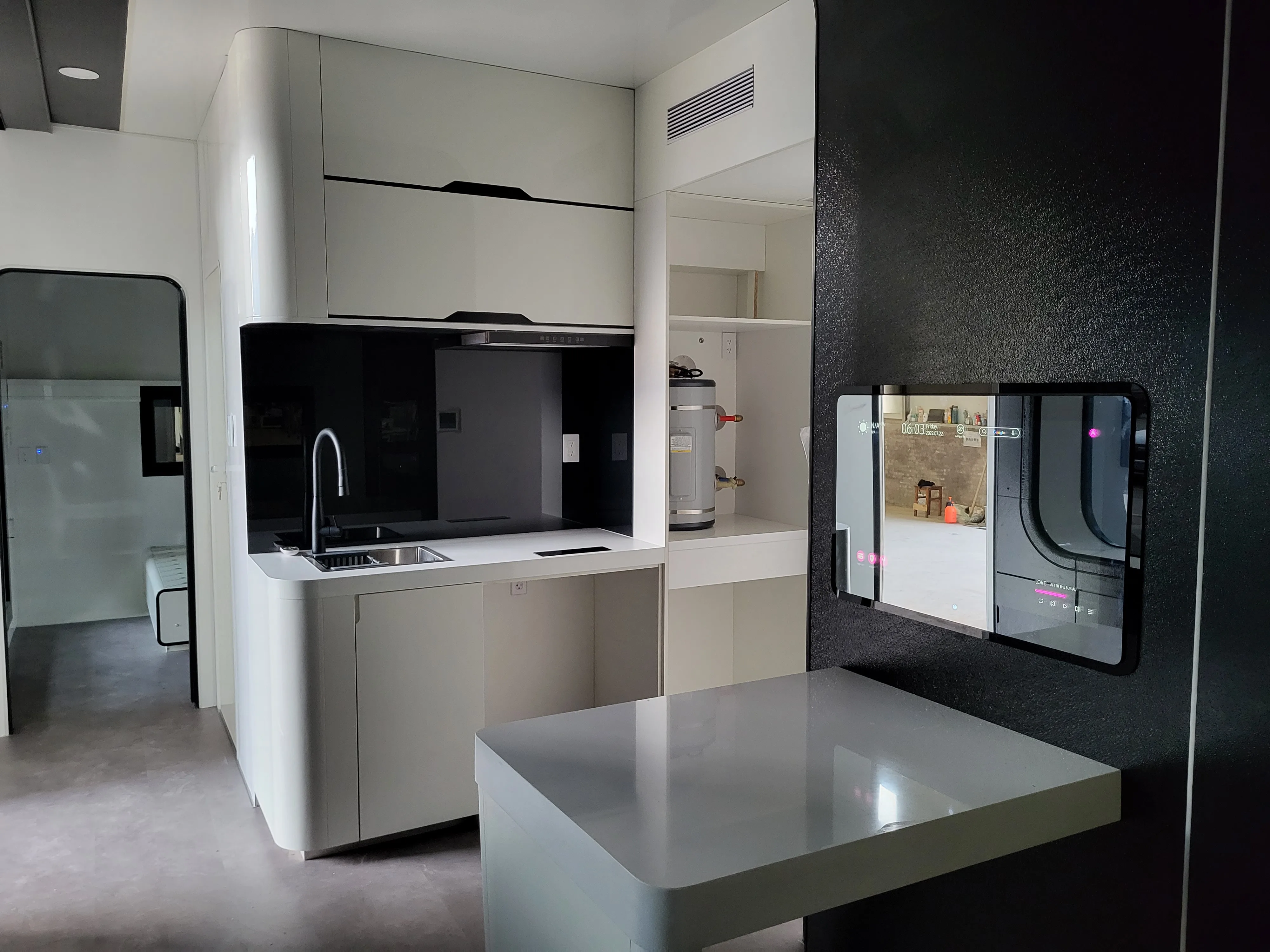  Nestron modular home kitchen with black countertops and smart mirror display, sustainability feature