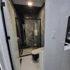 Nestron Cube Two X bathroom rendering with a glass shower enclosure, toilet, and dark interior finishes