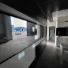 Nestron Cube Two X interior rendering showing a panoramic side window, built-in seating, and dark finishes
