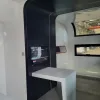 Nestron Cube Two X interior rendering with a compact table, dark cabinetry, and a large window