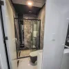 Nestron Cube Two X bathroom rendering with a glass shower enclosure, toilet, and dark interior finishes
