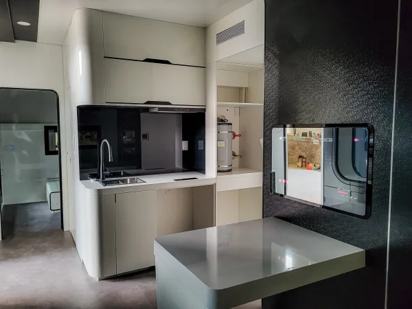 Nestron Cube Two X kitchen rendering with light cabinetry, built-in appliances, and a compact dining area
