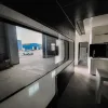 Nestron Cube Two X interior rendering showing a panoramic side window, built-in seating, and dark interior finishes