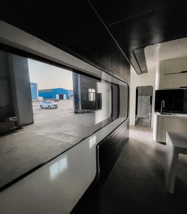 Nestron Cube Two X interior rendering showing a panoramic side window, built-in seating, and dark interior finishes