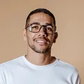 Portrait of a smiling man with glasses and short dark hair wearing a light shirt