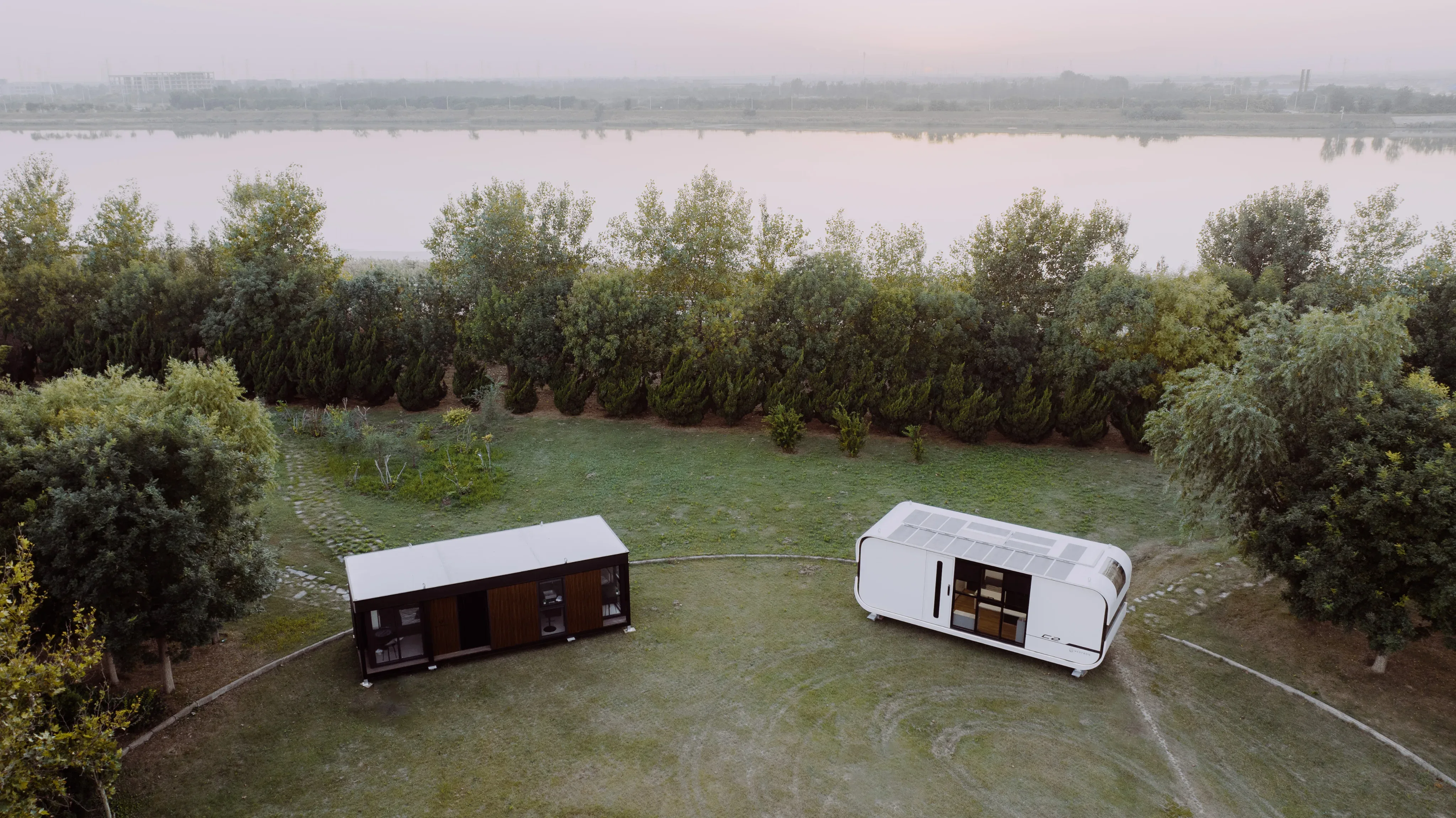 Elevated view of a white modular home positioned in a grassy outdoor setting