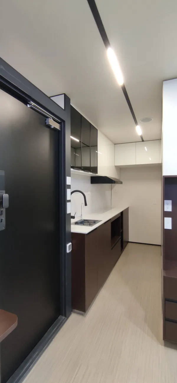 Nestron Legend One kitchen rendering with the black entry door open, showing countertop, cooktop, and cabinetry