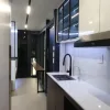 Nestron Legend One kitchen interior with a stainless sink, black faucet, range hood, and glass-front upper cabinets