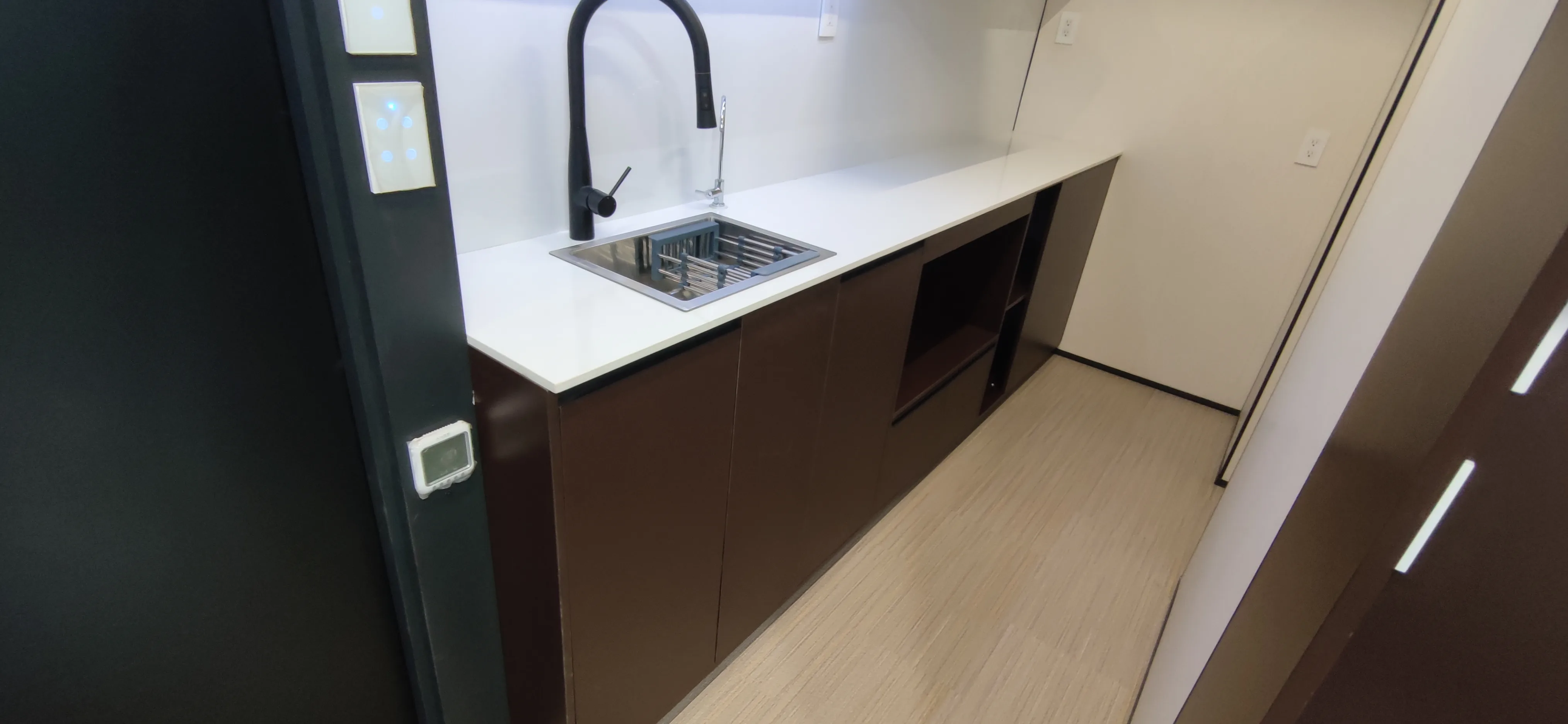 Nestron Legend One kitchen rendering with a white countertop, black faucet, and dark wood cabinetry