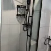 Close-up rendering of the Nestron Legend One bathroom with black shower fixtures and white tiled walls
