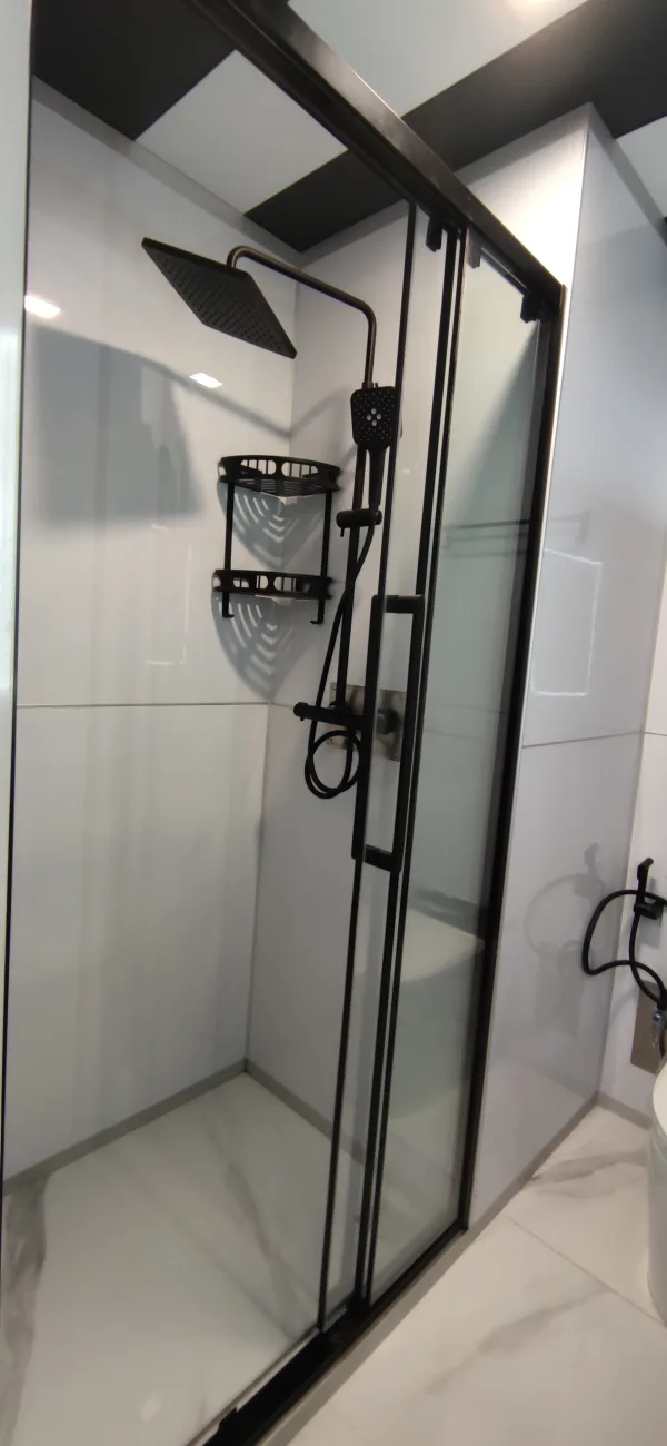 Close-up rendering of the Nestron Legend One bathroom with black shower fixtures and white tiled walls