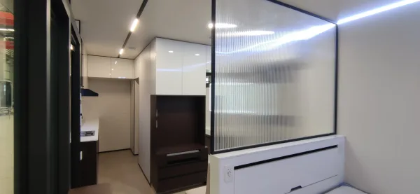 Nestron Legend One interior rendering showing a TV console, mirrored wall panels, and white cabinetry