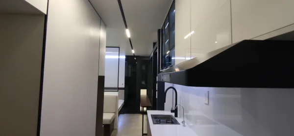 Nestron Legend One kitchen rendering with a white countertop, black faucet, dark cabinetry, and glossy wall panels