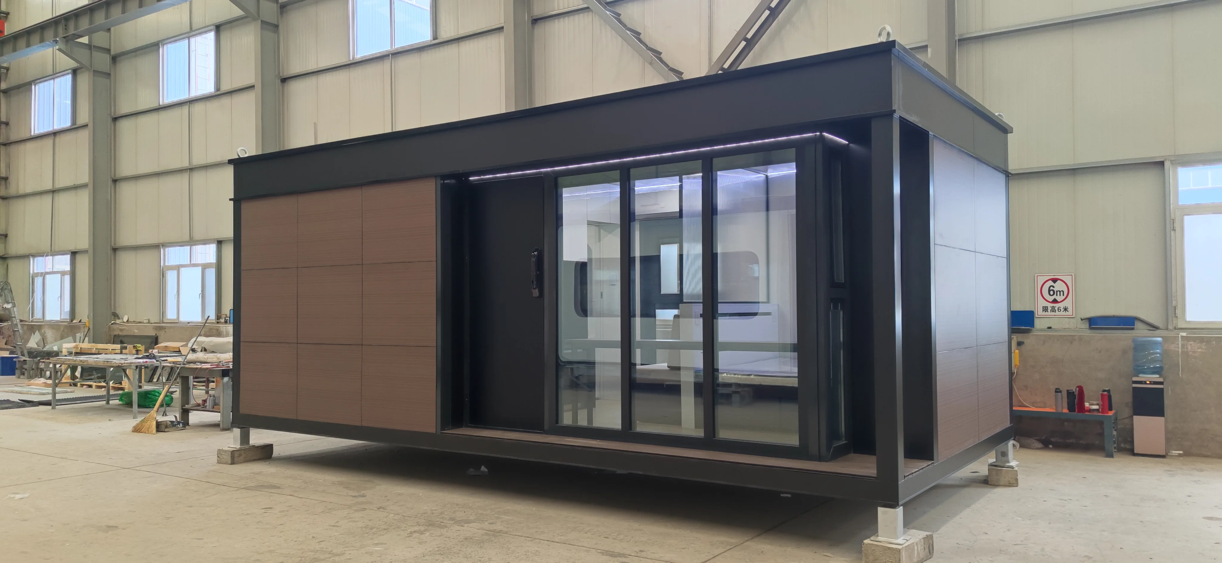 Side exterior rendering of the Nestron Legend One with large glass doors, brown facade panels, and dark trim