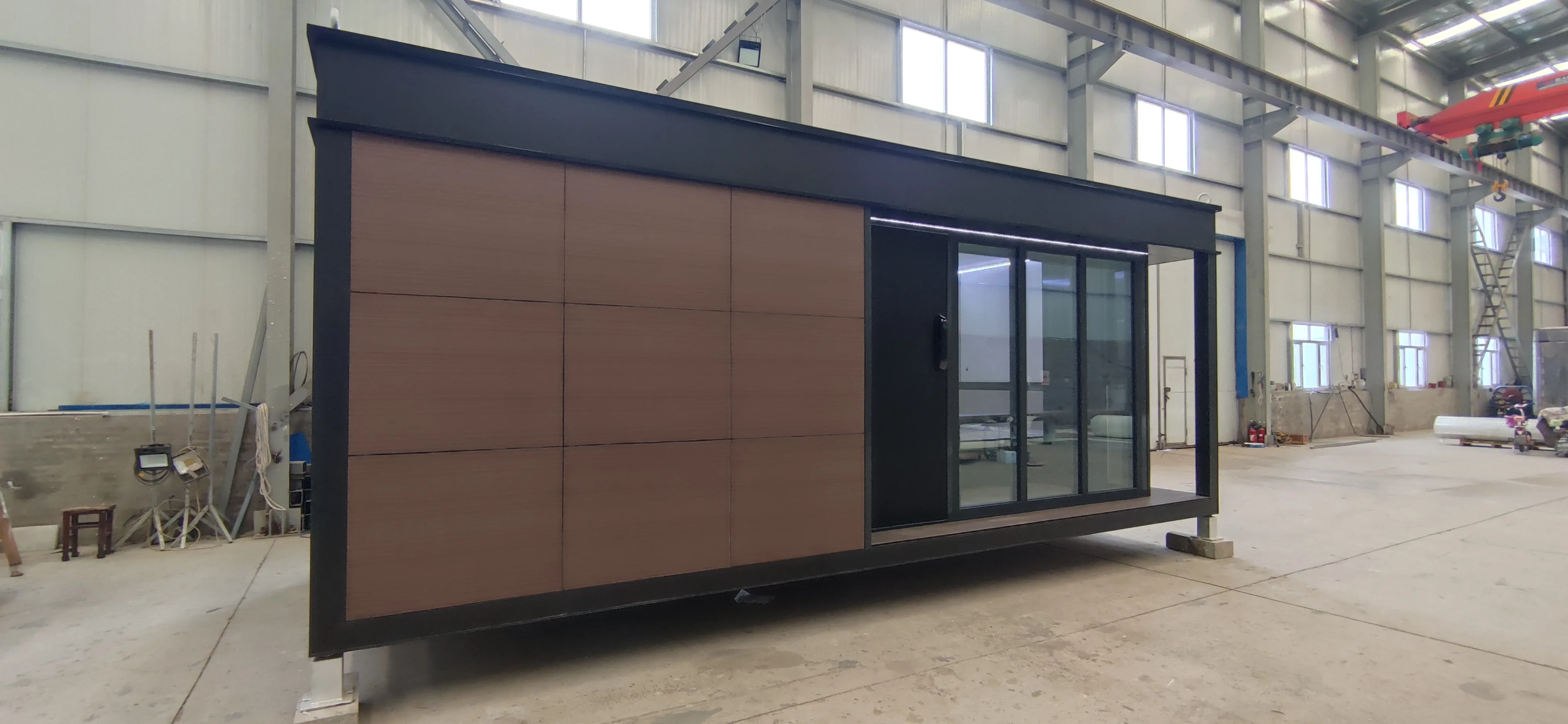 Side exterior rendering of the Nestron Legend One with brown facade panels and a large dark framed window