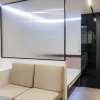 Nestron Legend One living area rendering with a beige sofa, illuminated wall panel, and dark interior accents