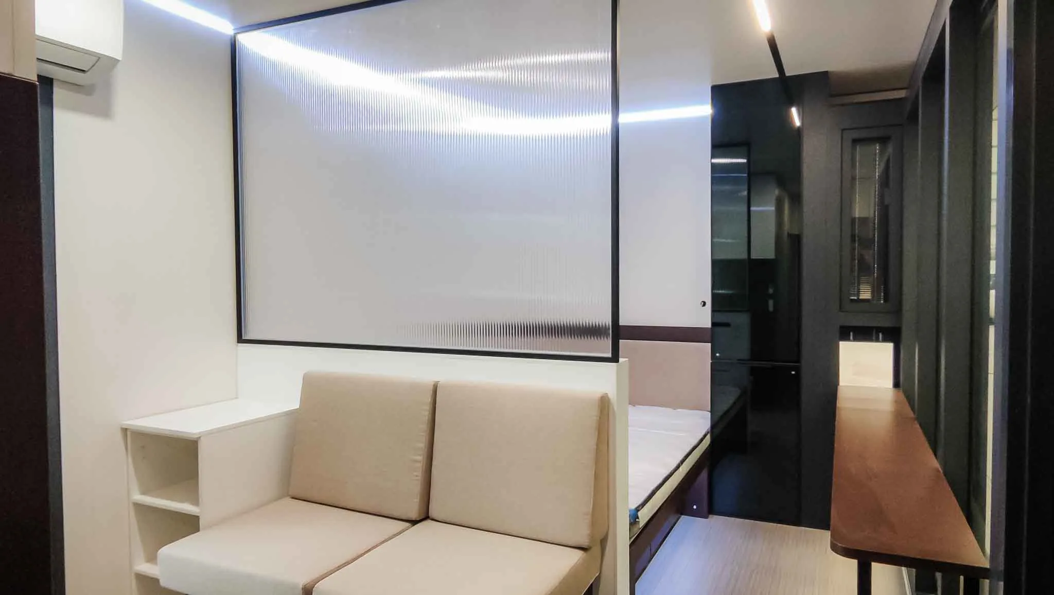 Nestron Legend One living area rendering with a beige sofa, illuminated wall panel, and dark interior accents