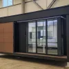Side exterior rendering of the Nestron Legend One with large glass doors, wood siding, and dark trim