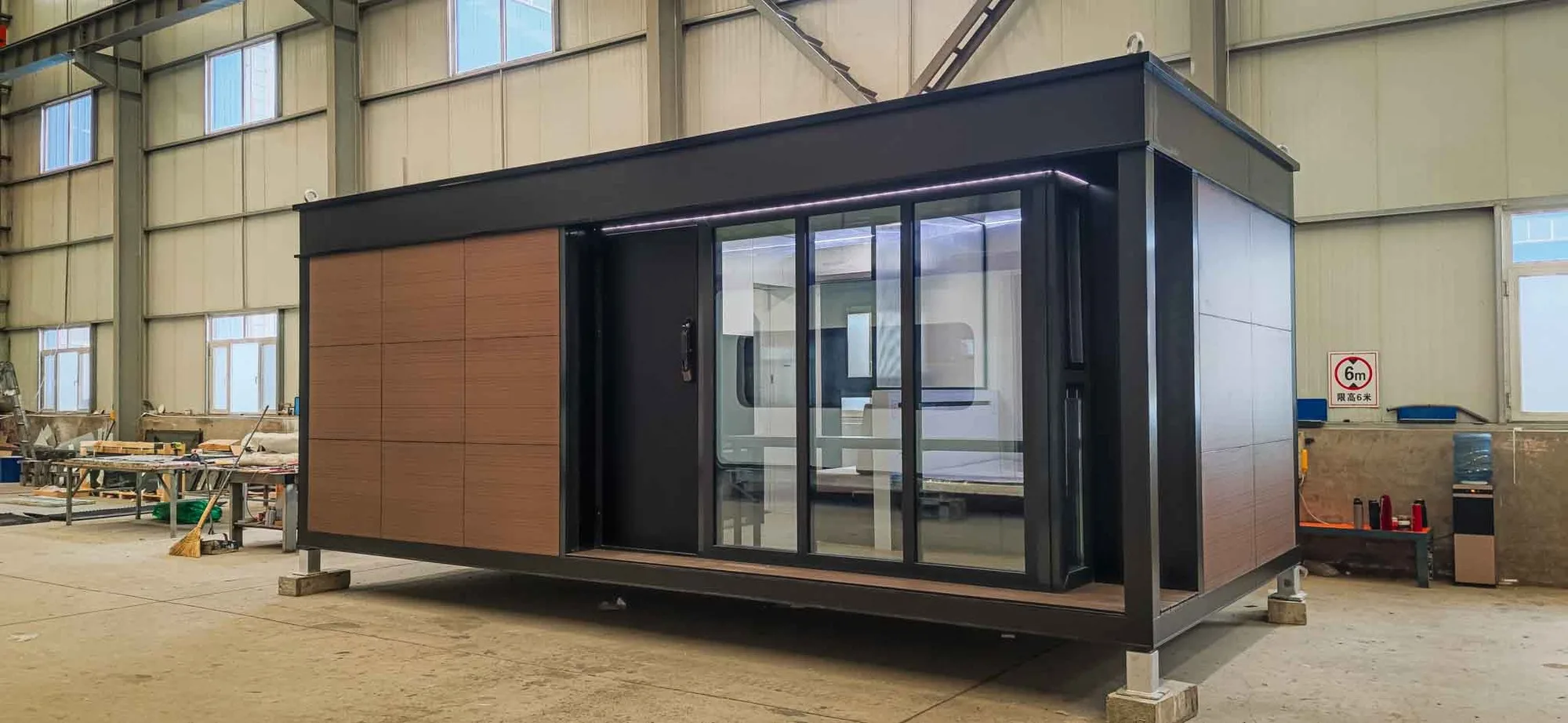 Side exterior rendering of the Nestron Legend One with large glass doors, wood siding, and dark trim