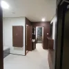 Nestron Legend Two interior rendering showing a bright hallway with dark wood doors, white walls, and built-in cabinetry