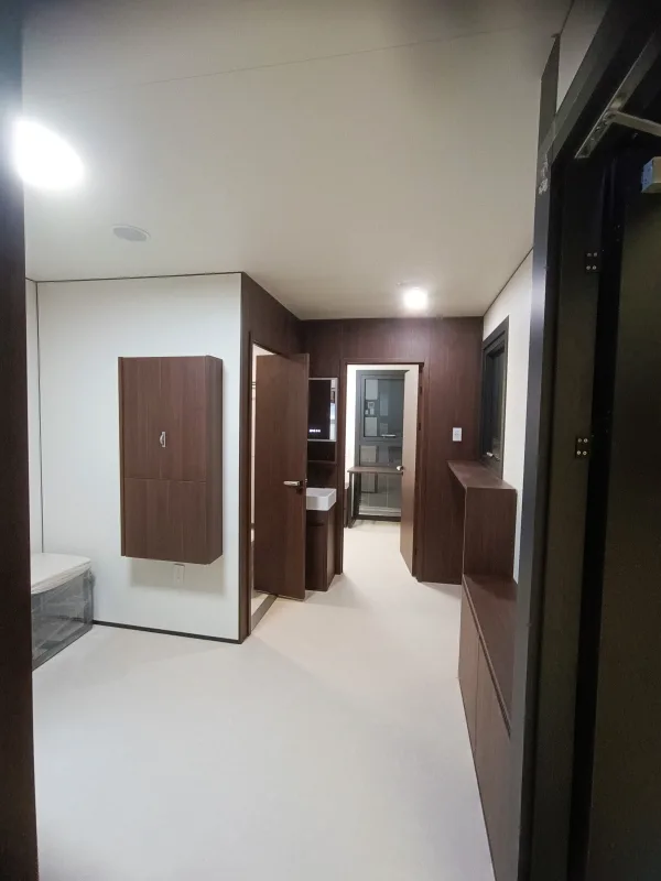 Nestron Legend Two interior rendering showing a bright hallway with dark wood doors, white walls, and built-in cabinetry
