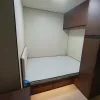 Nestron Legend Two bedroom rendering with a bed, white bedding, and dark wood wall panels