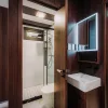 Nestron Legend Two bathroom rendering with dark wood wall panels, a white vanity, and mirror