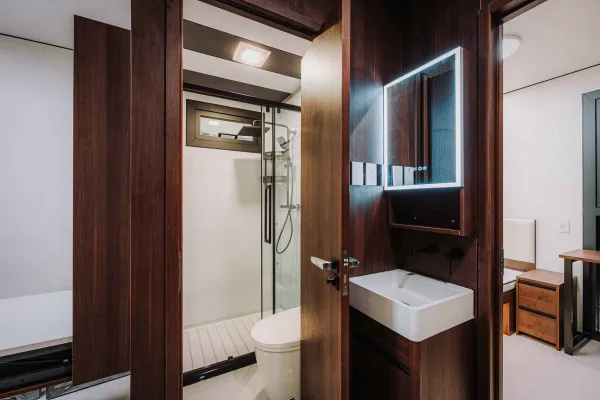 Nestron Legend Two bathroom rendering with dark wood wall panels, a white vanity, and mirror