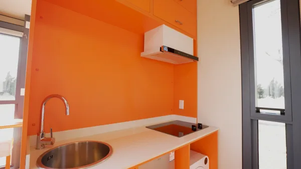 Nestron Legend Two kitchen rendering with orange cabinetry, white countertops, sink, and cooktop