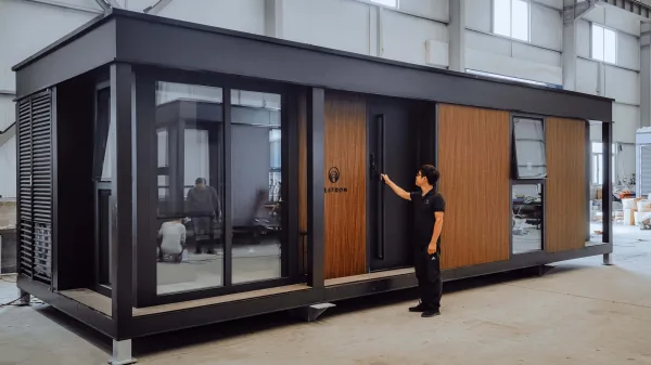 Nestron Legend 2 modular tiny home with wood-paneled exterior in a warehouse