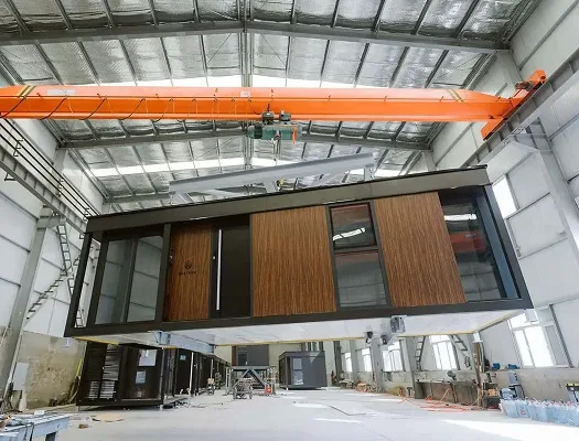 Interior view of a modular home production facility with units lined up along the factory floor