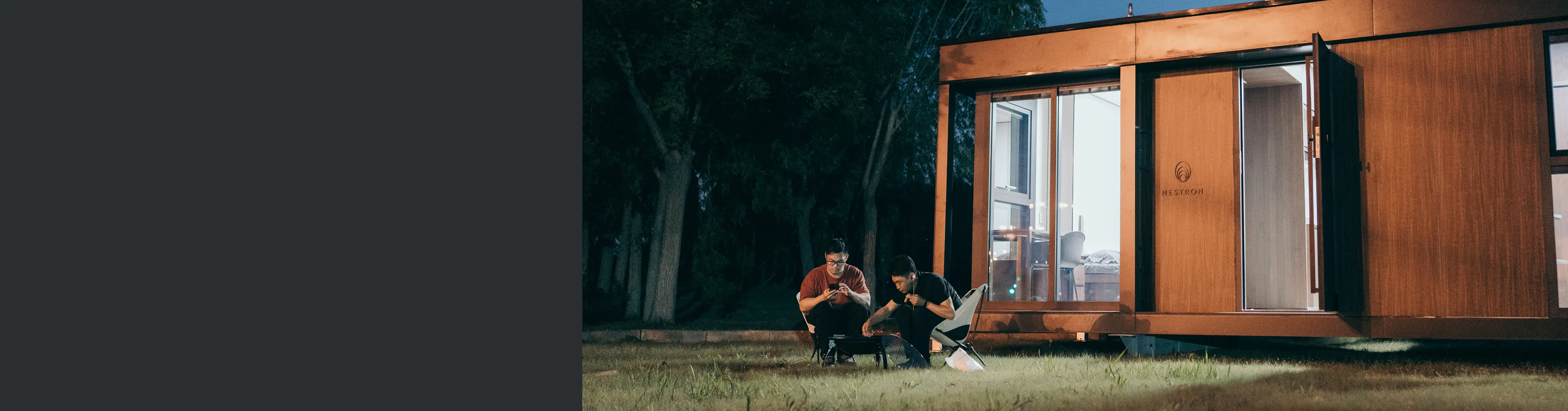 People relaxing outside a modern modular home in a wooded setting