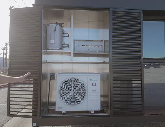 Exterior HVAC unit installed behind a louvered panel on a modular home